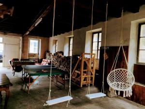 a room with a couch and a table and swings at Charmant gîte vosgien avec 13 chambres pour 30 personnes in Fellering