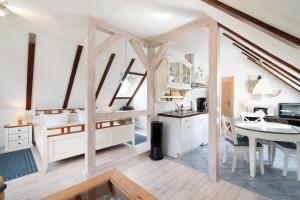 a kitchen and dining room with white cabinets and a table at Landstuuv in Neustadt in Holstein