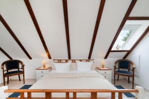 a bedroom with a bed and two chairs at Landstuuv in Neustadt in Holstein