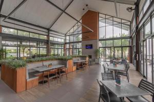 a restaurant with tables and chairs and windows at EdenNest in Boksburg