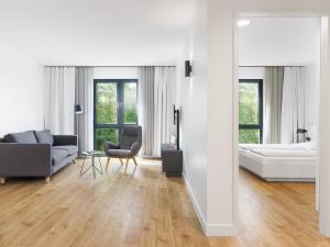 a white living room with a couch and a bed at smartments Berlin Karlshorst in Berlin