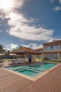 a resort with a swimming pool and a building at Pousada Aysú in Japaratinga