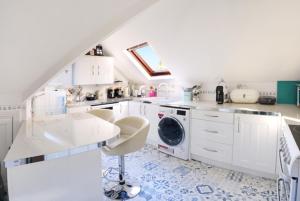 a white kitchen with a washing machine in it at Charming loft sleeps up to 9 with spa option in Bournemouth +157 photos