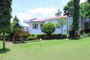 a yard with a playground in front of a house at Rocy Hotel in Mbale