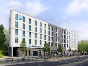 a large white building with bikes parked in front of it at smartments Berlin Karlshorst in Berlin