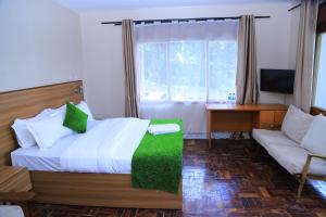 a bedroom with a bed and a couch and a window at Rocy Hotel in Mbale +29 photos
