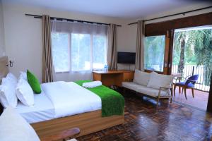 a bedroom with a bed and a desk and a chair at Rocy Hotel in Mbale