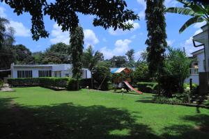 a yard with a playground and a house at Rocy Hotel in Mbale