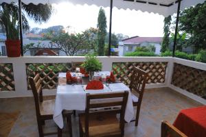 a table with a white table cloth on a balcony at Rocy Hotel in Mbale