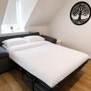 a bed in a room with a tree picture on the wall at Les Toits d'Arras in Arras