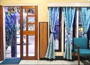 an open door with a blue chair and a window at D Mukta Lodge in Guwahati