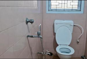 a bathroom with a toilet and a shower at D Mukta Lodge in Guwahati