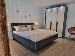 a bedroom with a large bed with white and pink pillows at Moselmoni in Bullay