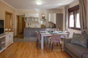 a kitchen and living room with a table and a couch at Apartman Sara s vrtom in Vantačići +11 photos