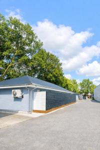 a white building with a parking lot and trees at Ado Pension in Wedel