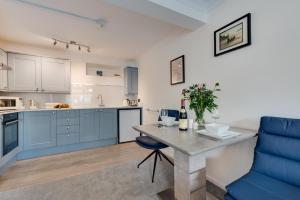 a kitchen with blue cabinets and a table with a bottle of wine at 1 Bed in West Looe oc-1west in Looe