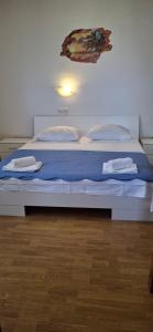 a bedroom with two beds with blue sheets at Apartments "Sun-sea" in Rab