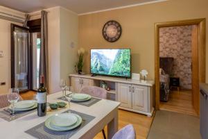 a living room with a tv and a table and chairs at Apartman Sara s vrtom in Vantačići