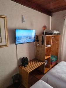 a bedroom with a tv on a wall with a bed at Maggie Rose Cottage Self Catering in Greyton in Greyton +11 photos