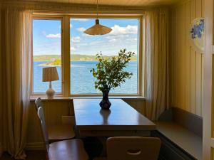 a table with a vase on it in front of a window at Romantic Summer House On Orust in Stillingsön