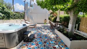 a garden with a tub and a patio with a tree at Mami in Malia