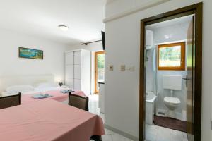 a room with a bed and a bathroom with a toilet at Apartments Pino Rabac in Rabac +50 photos