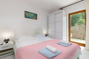 a bedroom with a large bed with two towels on it at Apartments Pino Rabac in Rabac