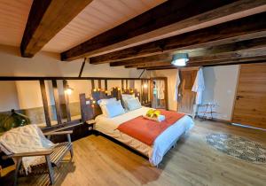 a bedroom with a large bed in a room with wooden floors at Gite L étable du Bien Etre in Ray-sur-Saône
