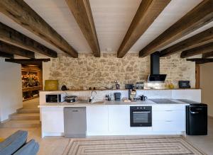 a kitchen with white appliances and a stone wall at Gite L étable du Bien Etre in Ray-sur-Saône