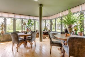 a dining room with a table and chairs and windows at Muckrach Country House in Skye of Curr