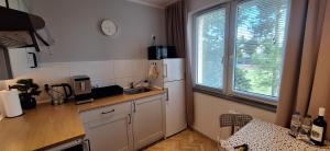 a kitchen with a white refrigerator and a sink at Zielone Okno Apartament w Augustowie blisko jeziora i centrum in Augustów