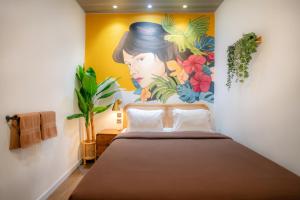 a bedroom with a bed with a painting on the wall at Snooze Yogyakarta in Yogyakarta +64 photos