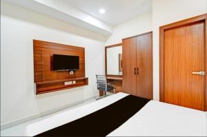 a bedroom with a bed and a tv on the wall at Hotel GREEN LEAF in Hyderabad