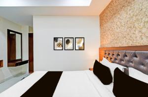 a bedroom with a large bed with black and white pillows at Hotel GREEN LEAF in Hyderabad