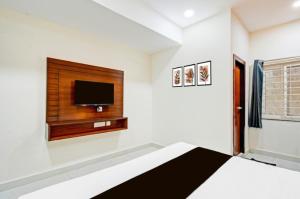 a bedroom with a bed and a flat screen tv at Hotel GREEN LEAF in Hyderabad +14 photos