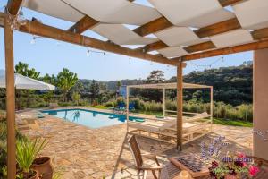 an outdoor patio with a pool and a pergola at Villa Rubin in Almyrida