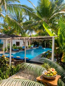 a resort pool with a bowl of fruit on a table at LITTLE POMPEJI Villa - Adults Only in Jambiani