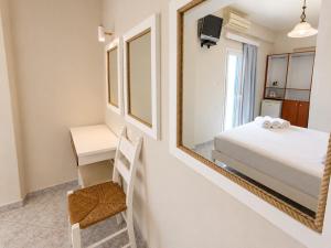 a bedroom with a bed and a mirror at Agia Roumeli Hotel adults only Ξενοδοχείο Αγία Ρουμέλη μόνο για ενήλικες in Agia Roumeli +45 photos
