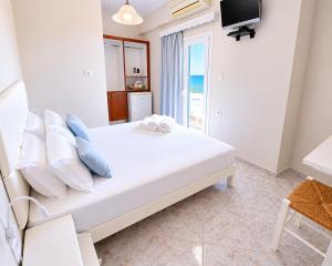 a bedroom with a bed with pillows and a television at Agia Roumeli Hotel adults only Ξενοδοχείο Αγία Ρουμέλη μόνο για ενήλικες in Agia Roumeli