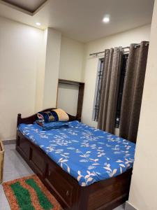 a bedroom with a bed with a blue comforter at Abc HOTEL & LODGE in Biratnagar