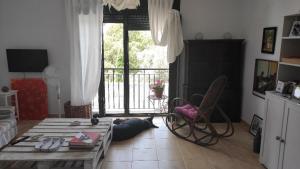 a living room with a table and a chair in front of a door at Beautiful Duplex with a Patio in Alcalá de los Gazules