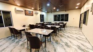 a restaurant with tables and chairs in a room at Appa Hillside Nature Resort in Karjat