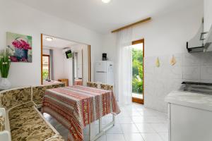 a kitchen with a table with a table cloth on it at Apartments Pino Rabac in Rabac