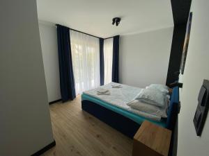a small bedroom with a bed and a window at Baltic Stay in Władysławowo