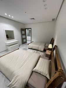 a bedroom with two beds and a tv on the wall at Villa with private Pool A in Al Khīrān