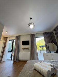 a bedroom with a bed with a television and a large window at Likani Stay in Borjomi