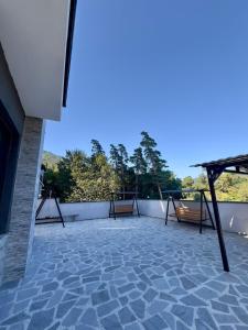 a patio with benches on top of a building at Likani Stay in Borjomi