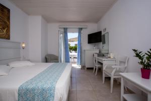 a hotel room with a bed and a table and chairs at Yiannaki Hotel in Ornos