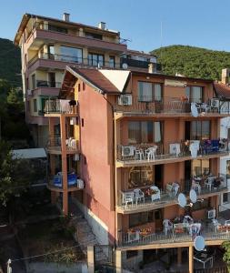 an apartment building with tables and chairs on the balconies at Joro Guest House in Sveti Vlas