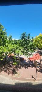 a park with two benches and a red umbrella at Torrent in Torrent